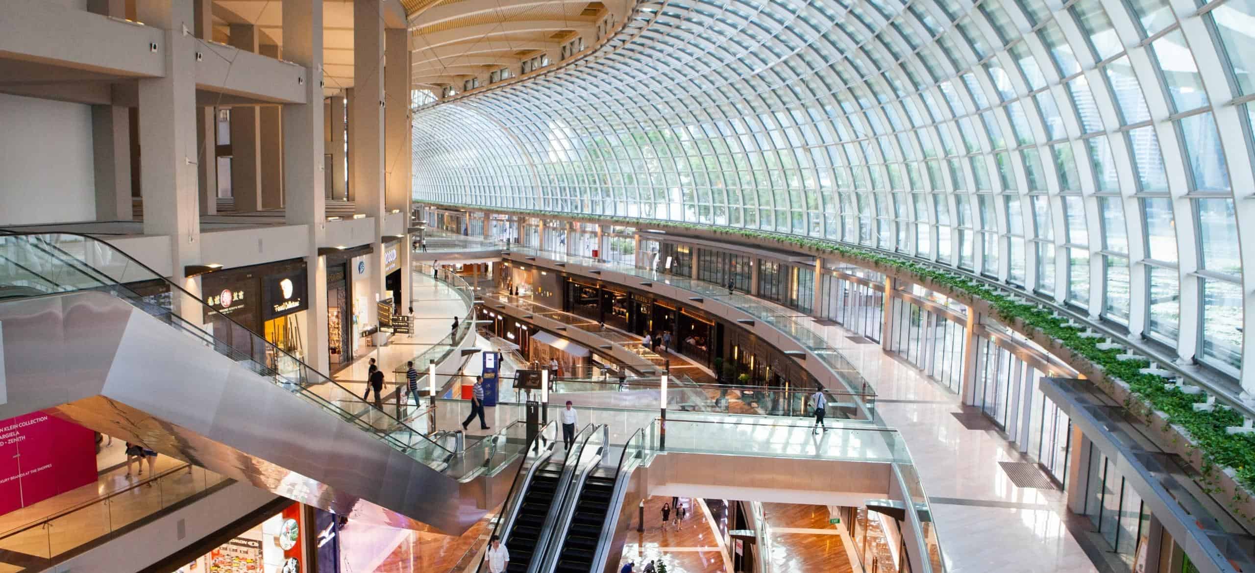 Vibrant and bustling retail scene in a busy mall, with shoppers exploring a variety of stores.