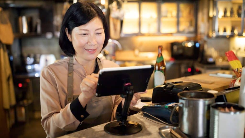 Restaurant manager managing at the counter using advanced omnichannel POS system