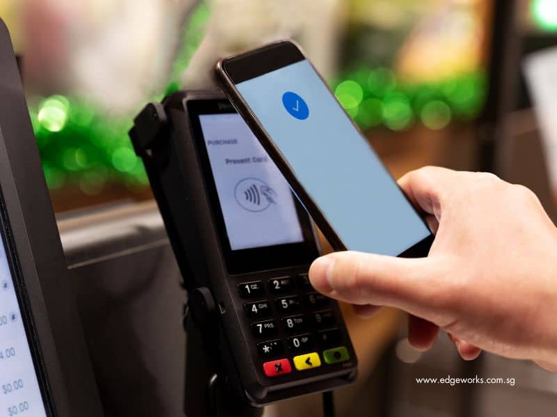 A person making payment via self-service kiosk with his/her mobile phone
